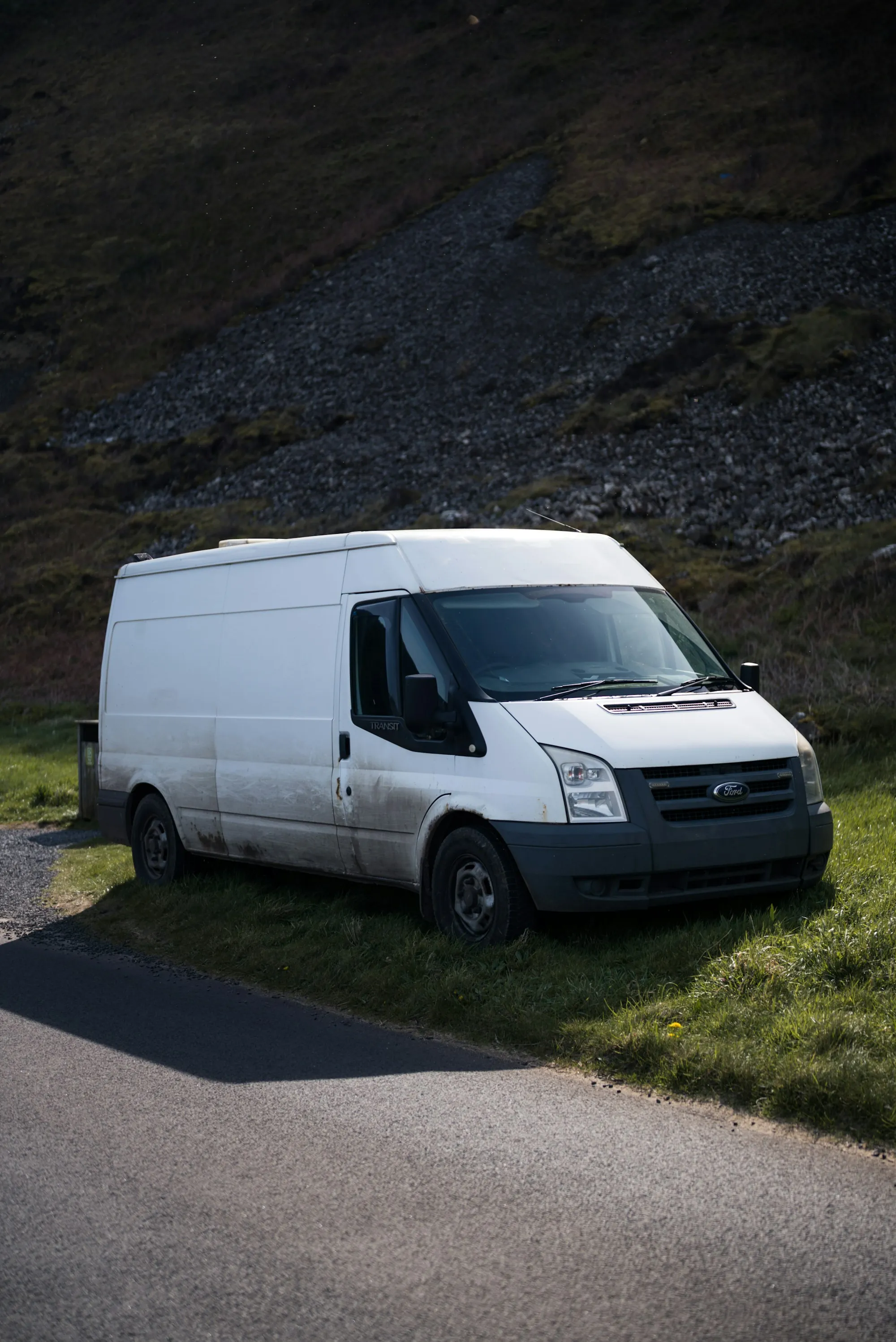 White work van parked on a gravel road